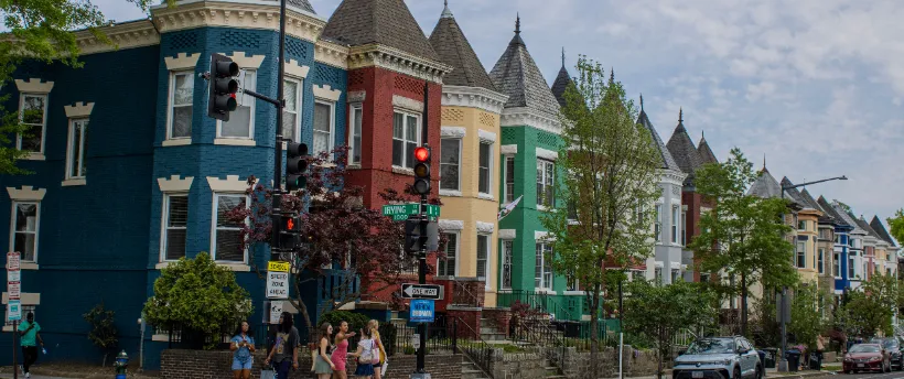A row of colorful DC rowhouses with front porches